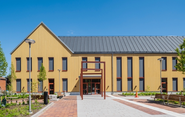 Flervåningshus med gul kulör och röda detaljer