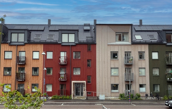 Fyra flervåningshus i gult, rött, grått och grönt