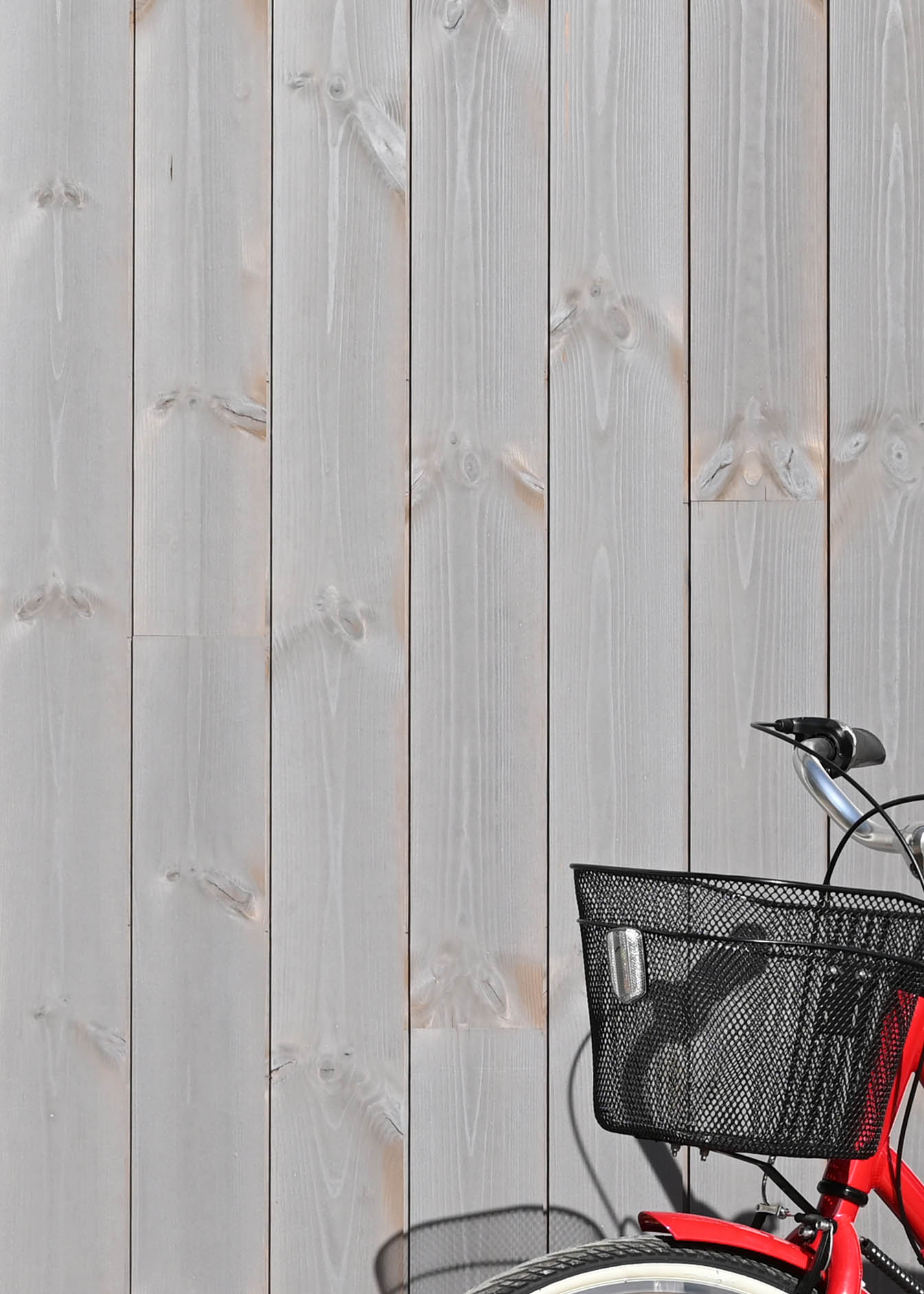 Patinagrå ytterpanel ThermoWood och röd cykel