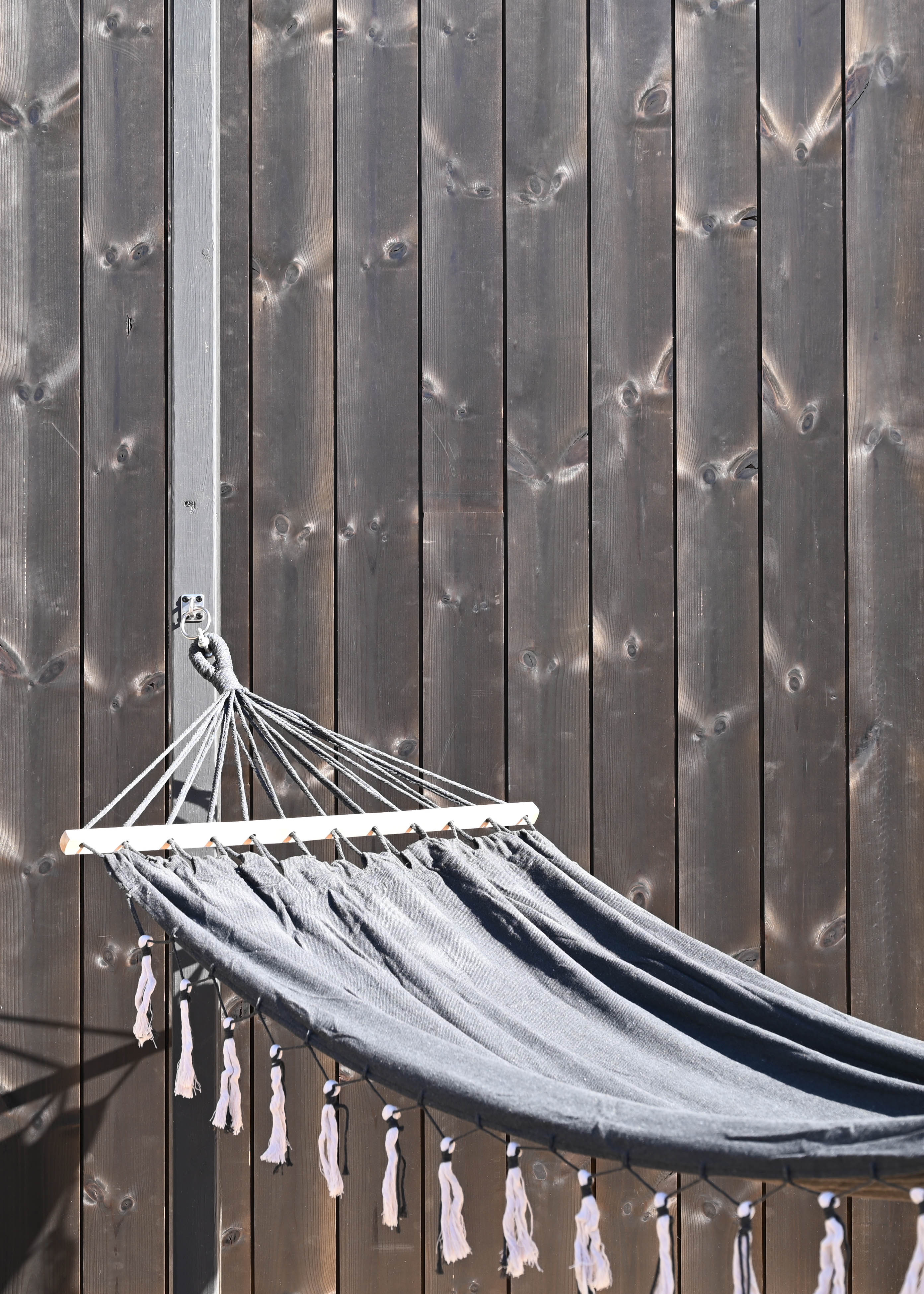 Svart ytterpanel ThermoWood och en hängmatta