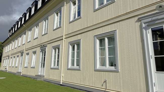 Studenthjem med ferdigmalt trefasade uten synlig innfesting