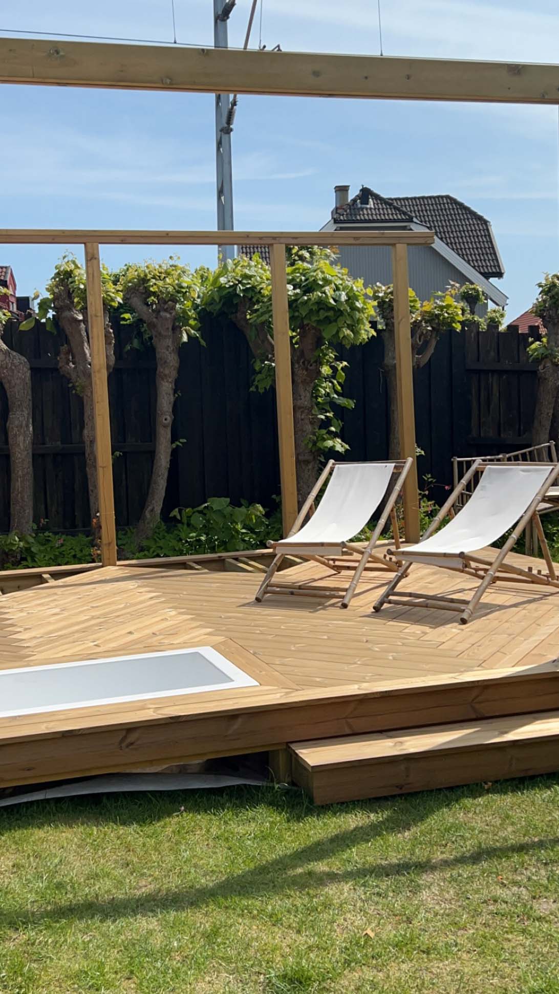 Et badekar er bygget inn i terrassen av termofuru fra Moelven. 