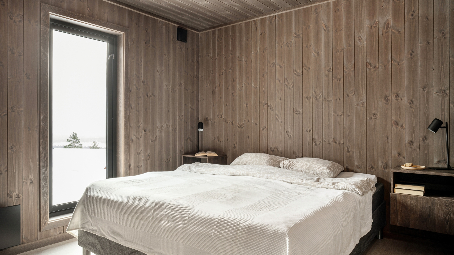 Soverom med stort vindu og varmt trepanel