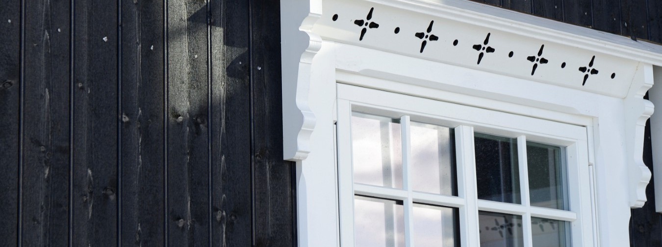 Et tradisjonsrikt norsk hus med kledning fra Moelven, sort kledning og hvite vinduer og detaljer