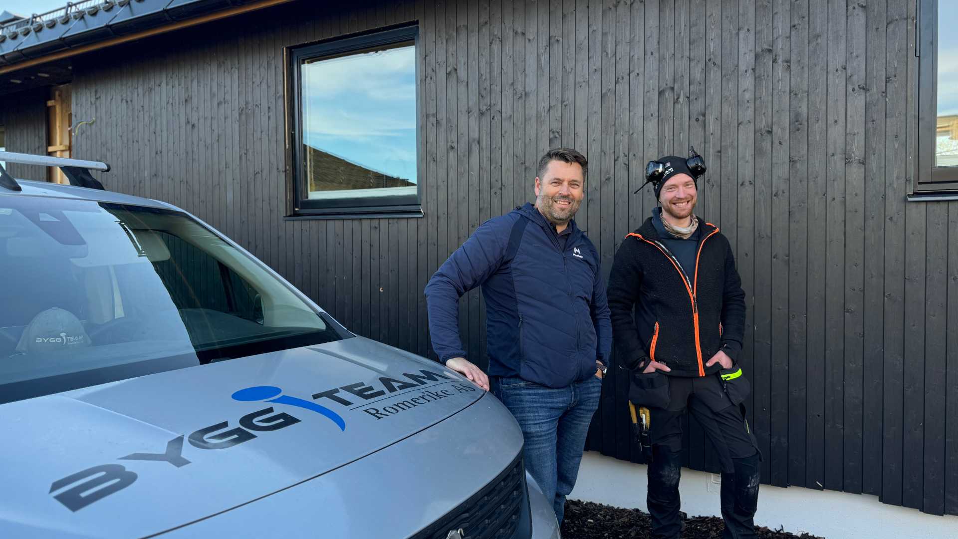 Leif Snilsberg, distriktsjef i Moelven, og tømrer Fredrik fra Bygg-Team Romerike foran huset med Heftig PRO+ kledning