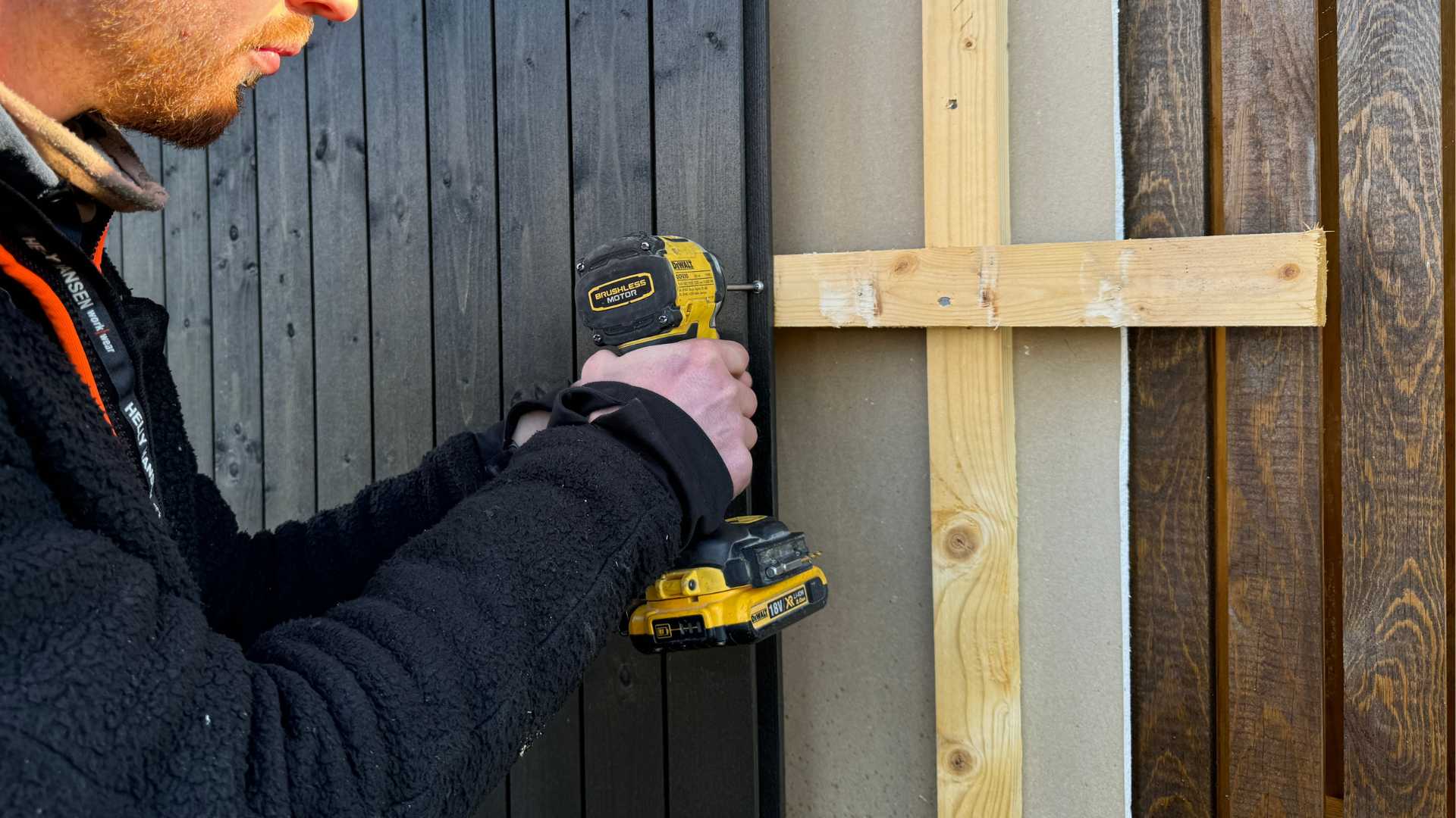 Tømrer monterer Heftig PRO+ kledning med skjult innfesting ved hjelp av skrutrekker