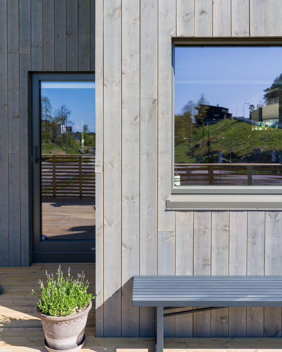Skjermet uteplass med stående Værbitt kledning i fargen Gråna og lys