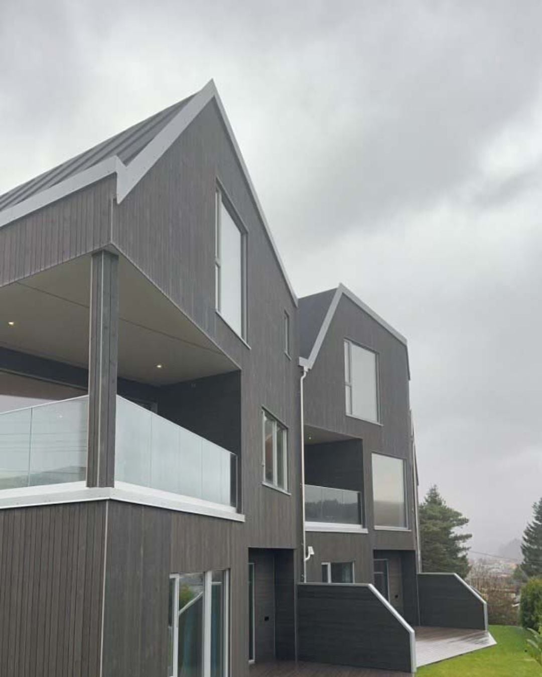 Moderne boliger med saltak og stående grå Værbitt kledning i fargen Herja.
