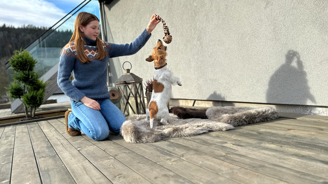 Terrassebord grå royal fra Moelven, men en ung jente og en hund som leker