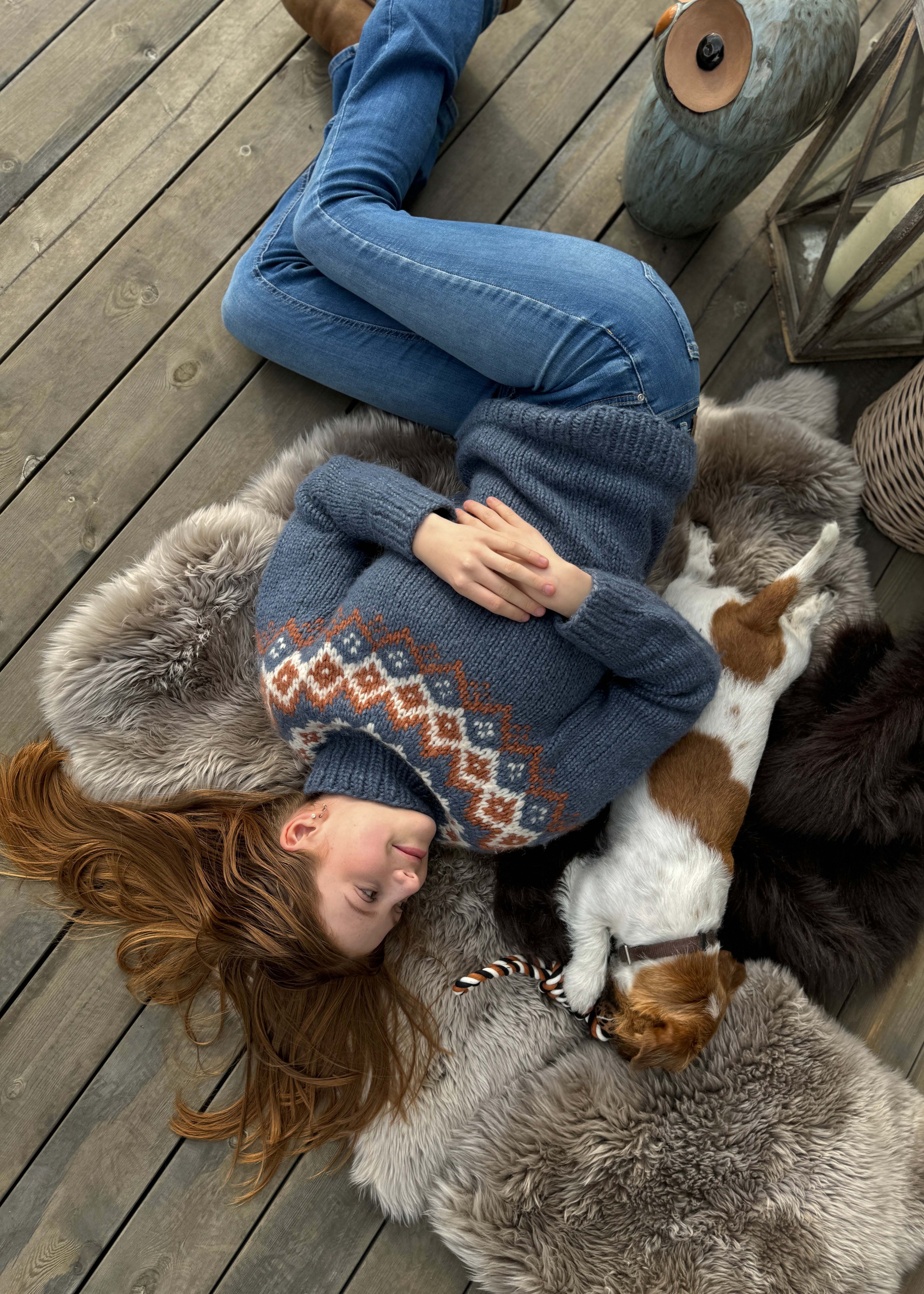 Jente og hund ligger på terrasse av Moelven grå royalterrasse