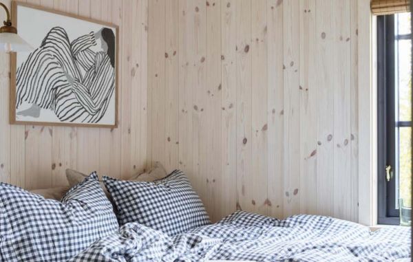 Trepanel sprekk i hvitlasert på en hytte, på soverommet, rutete sengetøy