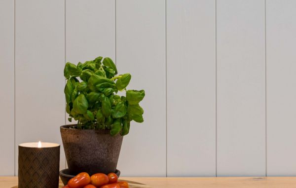 Trepanel sprekk i malt hvit klassisk på kjøkken med basilikumplante, tomater og levende lys