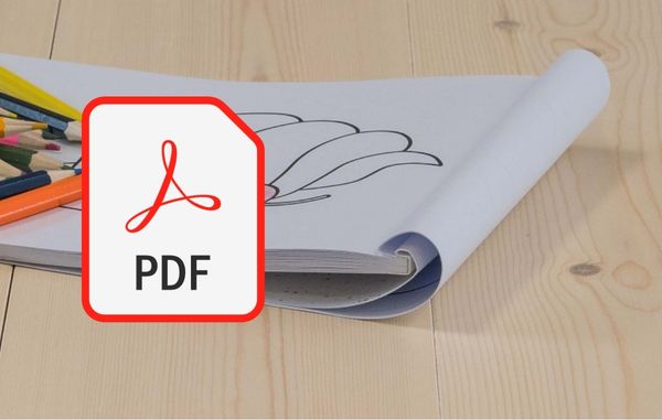 Tegneark og fargeblyanter på et lyst tregulv, med PDF-symbol i forgrunnen.