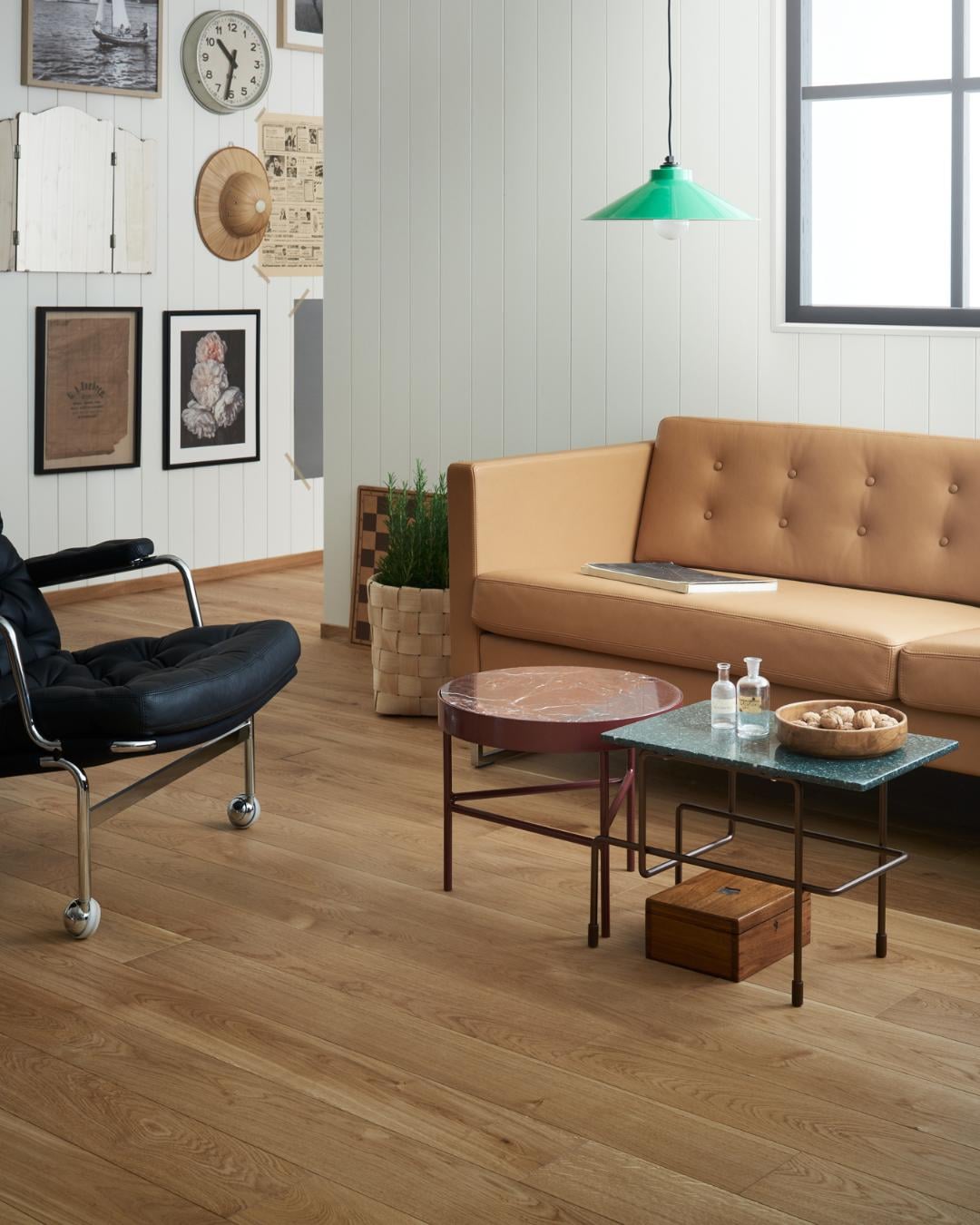 Moderne stue med oljet eikegulv, karamellfargede sofaer og retro møbler