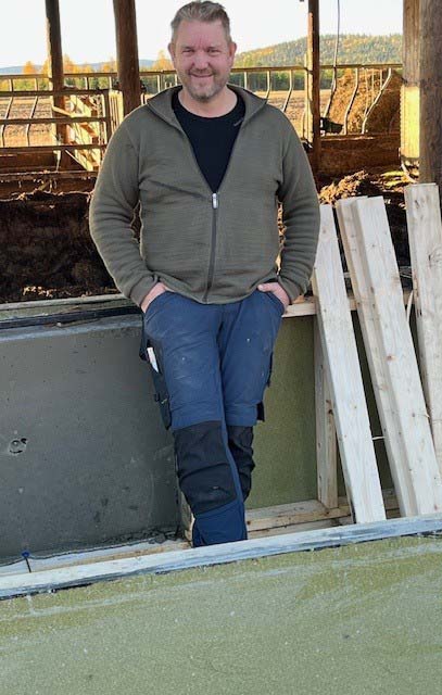 Byggmester foran muren han har støpt på fjøsprosjektet sitt