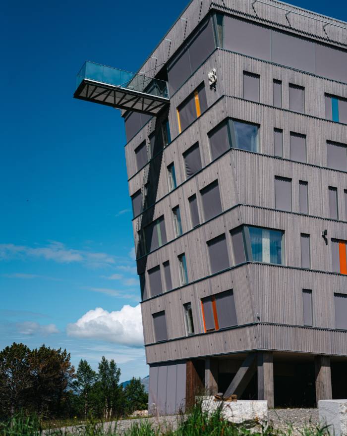 Høyt hotellbygg med grå fasadekledning i tre